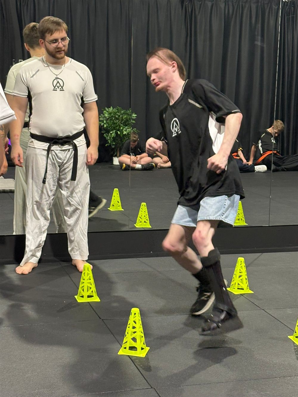 A participant kicking with instructor support